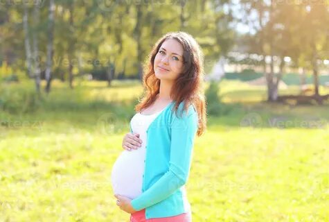 Pretty smiling pregnant woman in sunny summer day 994286 Sto