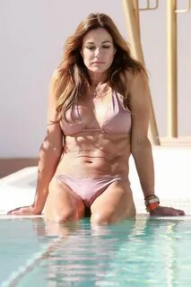 Kelly Bensimon posing in skimpy flesh colored bikini poolsid