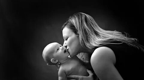 Black and white portrait of young mother kissing her baby - 