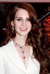 Lana Del Rey wearing a white pantsuit with red jewel ruby st