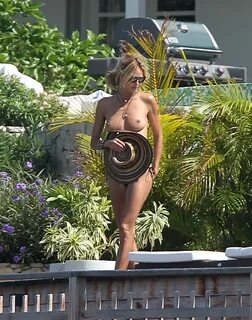 Heidi Klum tanning topless poolside in St. Barts