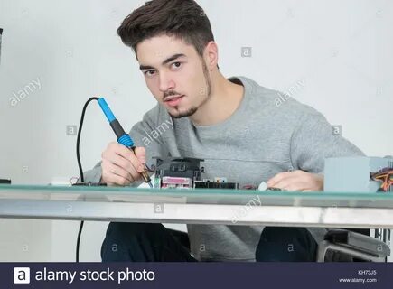 young man holding soldering iron Stock Photo - Alamy