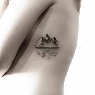 Reflection of mountains in water tattooed on the left rib ca
