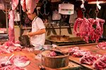 A butcher at a meat market scene in Guangzhou, China. Flickr