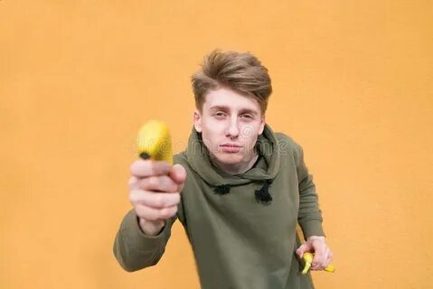 Funny Guy Holds a Banana in His Arms and Looks at the Camera