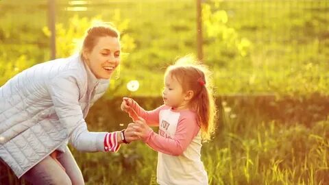 mom daughter blowing on dandelion wearing Stok Videosu (%100