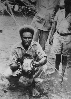 Woman holding severed head of japanese soldier