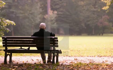 Old man sitting on a bench in autumn, autumn of life - Licen
