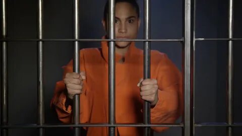 Young woman behind bars in jail cell Stock Video Footage 00: