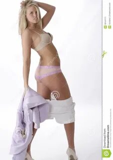 Photo about Beautiful young woman taking her clothes off. 
