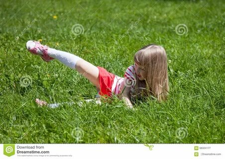 Little girl lying on grass stock image. Image of merriment -