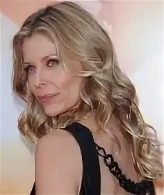 Kate Vernon wearing her hair with long spiral curls that flo