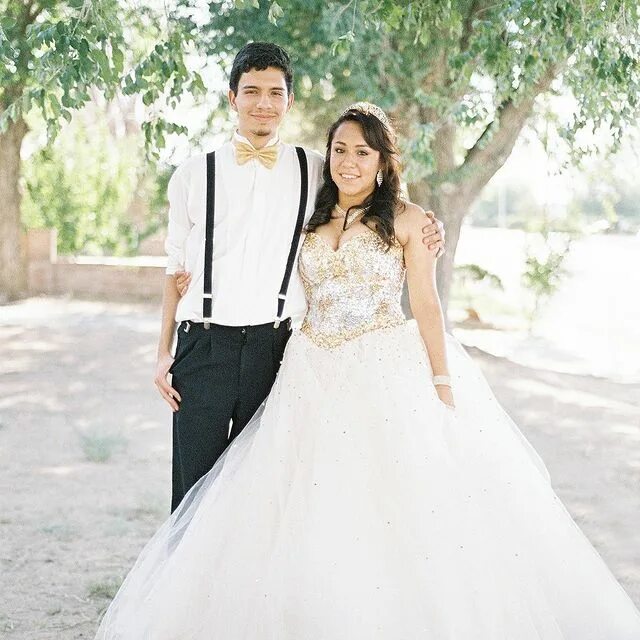 Quinceañera in champagne dress with her chambelan de honor under a willow t...