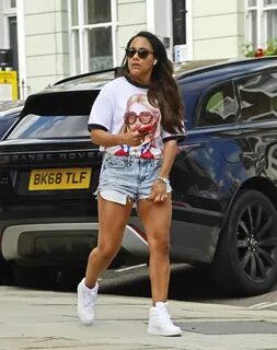 Alex Scott In denim shorts and a t-shirt while pictured enjo