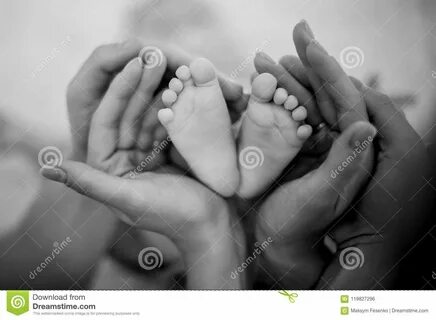 Мать и отец держа в их ногах дочери рук на кровати Стоковое 