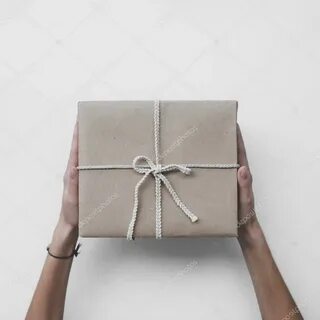 Parcel or gift wrapped in kraft paper with white ribbon, wit