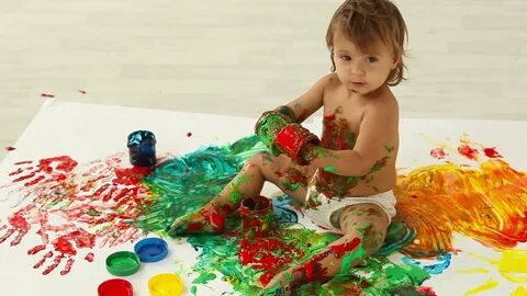 Lovely toddler having a good time making a mess of finger pa