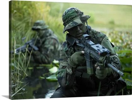U.S. Navy SEALs cross through a stream during combat operati