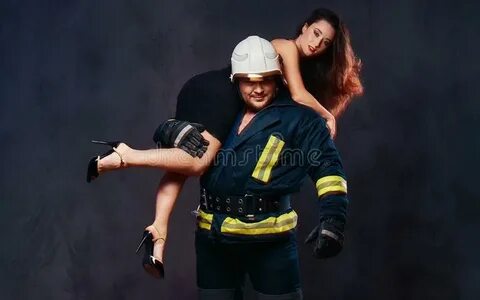 Пожарный держит женщину стоковое фото. изображение насчитыва