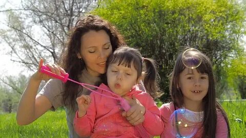 mom daughter blow bubbles family park: стоковое видео (без л