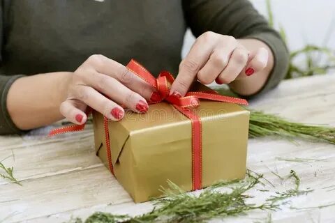 Woman Tying a Red Ribbon Around a Gift Stock Photo - Image o