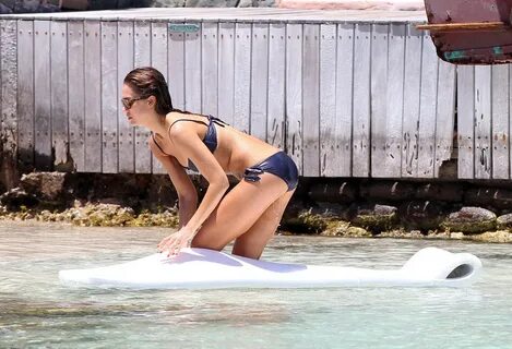Jessica Alba wearing a skimpy dark blue bikini on a beach in