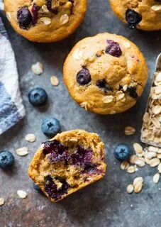 homemade healthy blueberry muffins surrounded by fresh blueb