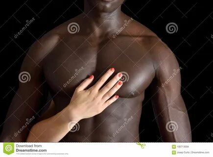 A white woman`s hand on a muscular chest of a black man.