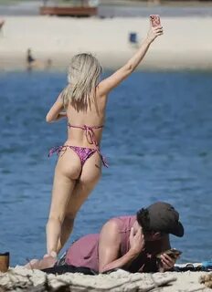 A bikini-clad Jessika Power turns on the PDA at the beach wi