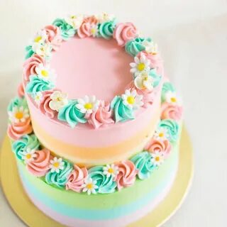 Pastel rainbow two tier cake with fondant daisies Tiered cak