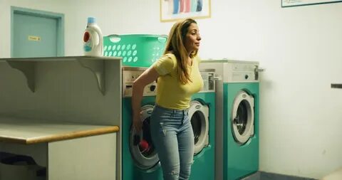 middle-aged tired woman turning washing machine Stok Videosu