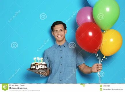 Young Man with Birthday Cake and Balloons on Color Backgroun