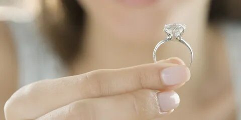 Woman holding beautiful diamond engagement ring - Lewis Malk