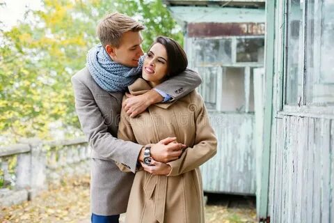 Young Couple in the Autumn Park. the Guy Hugs the Girl from 