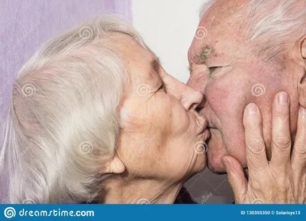 Красивые старшие женщины целуя счастливых людей дома.
