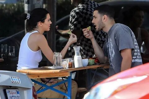 kendall jenner wears a white tank top and cargo pants while 