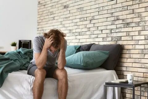 Depressed Young Man Sitting on Bed Stock Photo - Image of ba