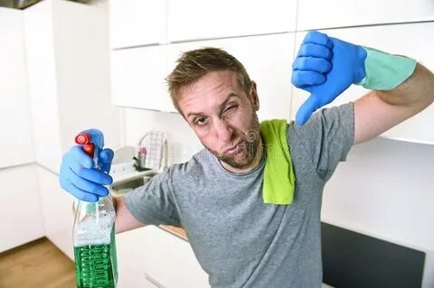 Young Sad Man in Rubber Gloves Cleaning with Detergent Spray