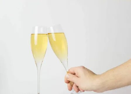 Pinke Rosen in goldener Flasche neben Glas Champagner bildet