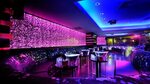 Interior discoteca luces neon barra taburetes pista baile wa