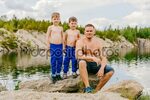 Pai e seus dois filhos sem camisa na margem do summe lagoa -
