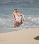 Hailey Baldwin in a floral nude swimsuit washing her sandy a