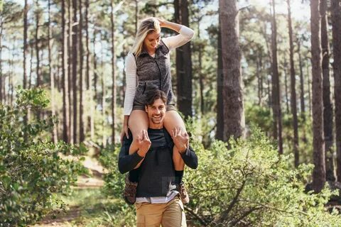 Man carrying his woman partner on his shoulders while trekki