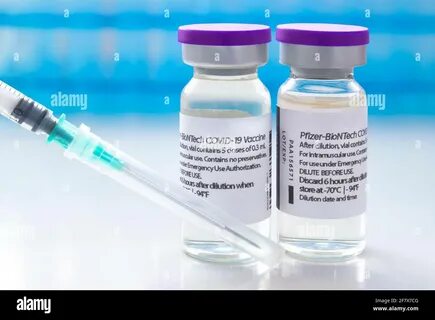 A couple of Pfizer dosis of Covid-19 vaccines on vial bottles and an inject...