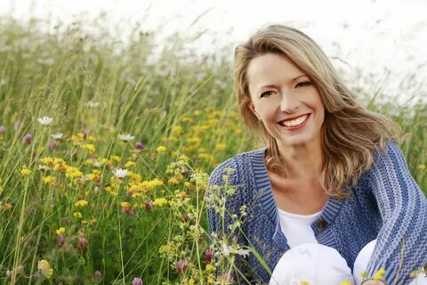 37410075 - happy middle aged woman in wild flower field.