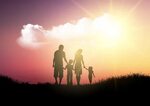 Silhouette of a family walking against a sunset sky 267279 V