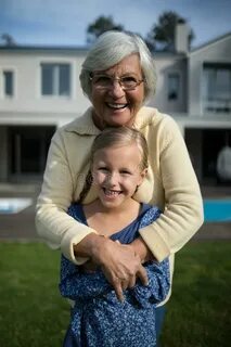 Smiling Grandmother and Granddaughter Embracing Each Other i