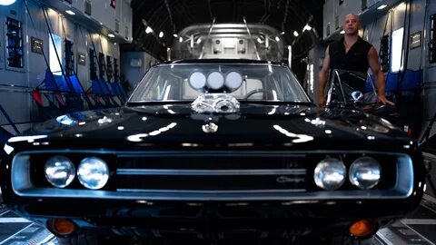 Vin Diesel stands beside a Dodge Charger in "Fast X" .
