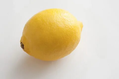 One lemon on white table - Free Stock Image