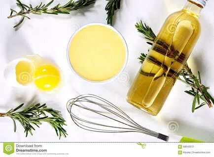 Bowl of homemade mayonnaise, broken egg, bottle of oil and wire wisk. top v...